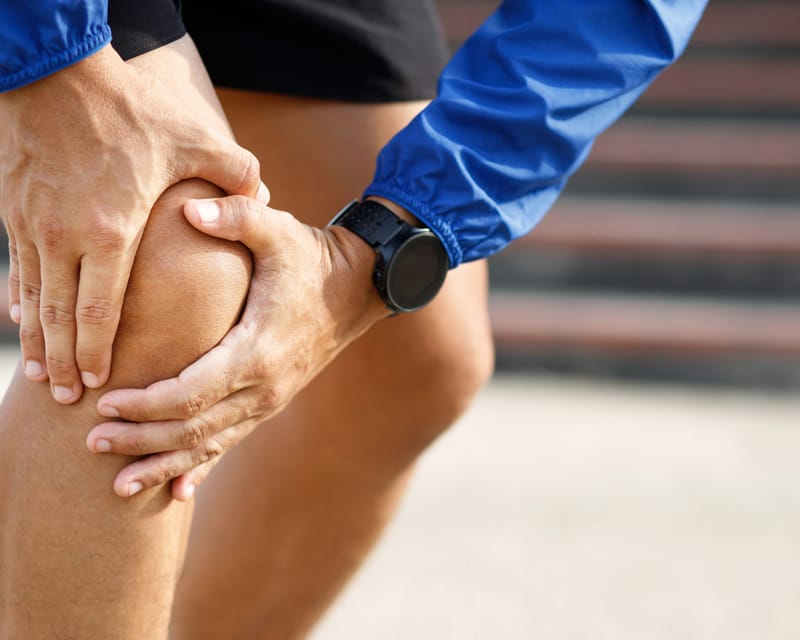 Person holding injured knee